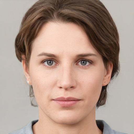 Joyful white young-adult female with medium  brown hair and grey eyes