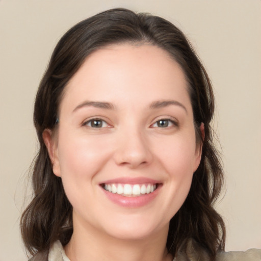 Joyful white young-adult female with medium  brown hair and green eyes