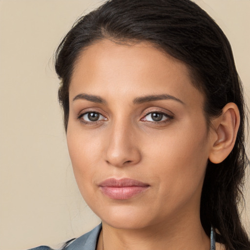 Joyful latino young-adult female with long  brown hair and brown eyes