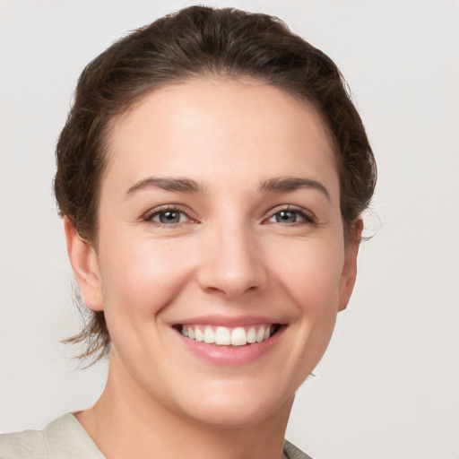 Joyful white young-adult female with short  brown hair and grey eyes