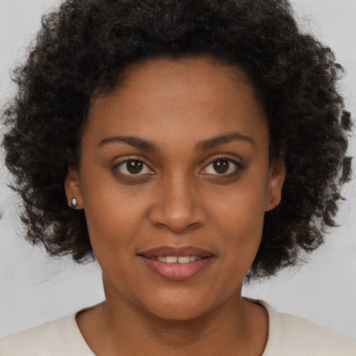 Joyful black young-adult female with medium  brown hair and brown eyes