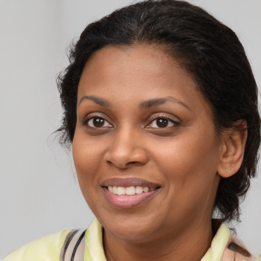Joyful black young-adult female with medium  brown hair and brown eyes
