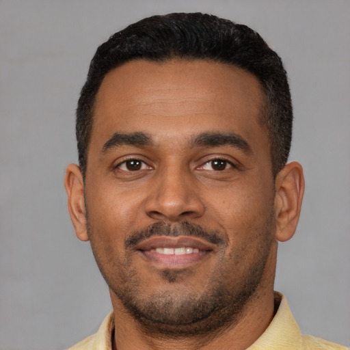 Joyful latino young-adult male with short  black hair and brown eyes