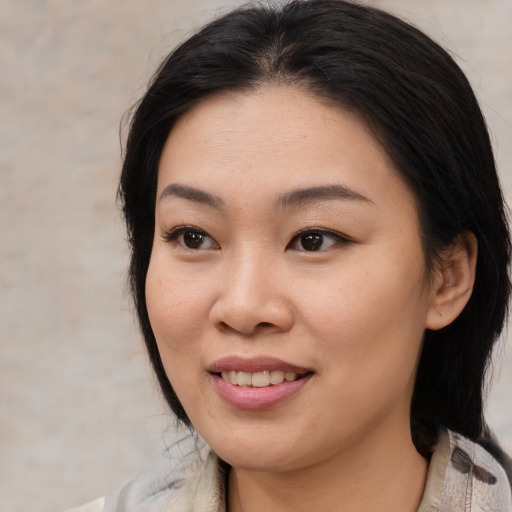 Joyful asian young-adult female with medium  brown hair and brown eyes