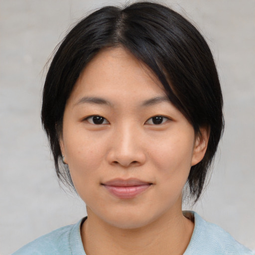 Joyful asian young-adult female with medium  black hair and brown eyes