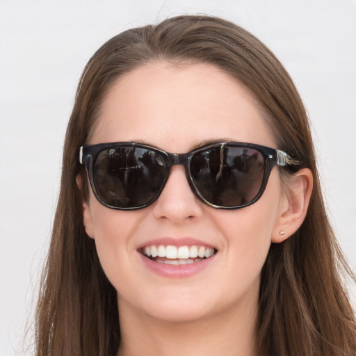 Joyful white young-adult female with long  brown hair and blue eyes