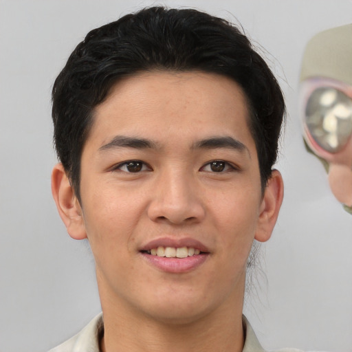 Joyful asian young-adult male with short  brown hair and brown eyes