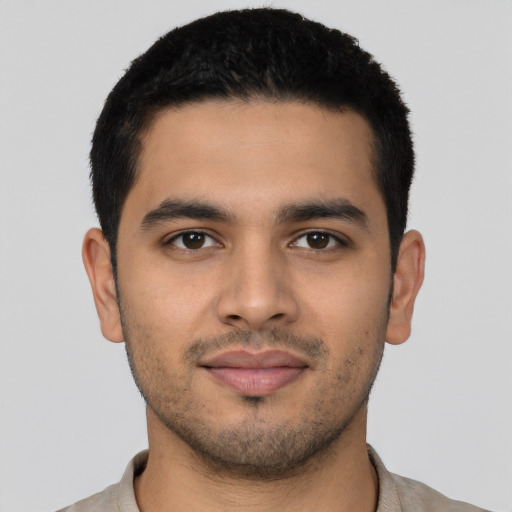 Joyful latino young-adult male with short  black hair and brown eyes