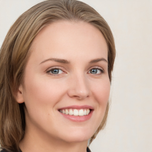 Joyful white young-adult female with medium  brown hair and green eyes