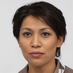 Joyful asian adult female with medium  brown hair and brown eyes