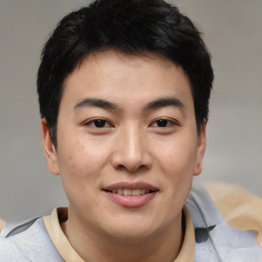 Joyful asian young-adult male with short  brown hair and brown eyes