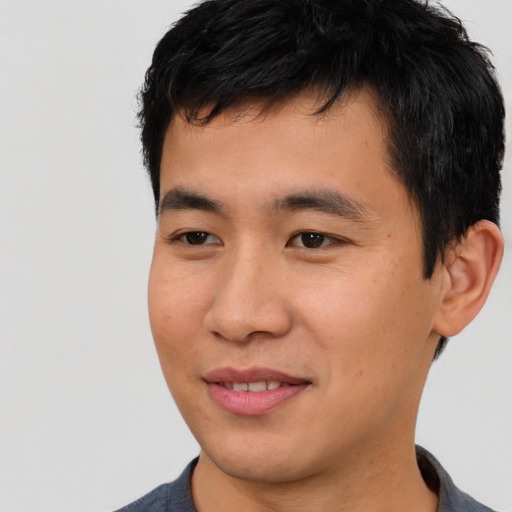 Joyful asian young-adult male with short  black hair and brown eyes