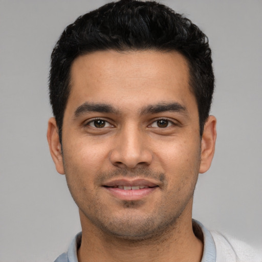 Joyful latino young-adult male with short  black hair and brown eyes