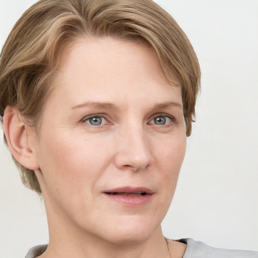 Joyful white adult female with short  brown hair and blue eyes