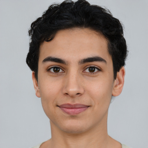 Joyful latino young-adult male with short  black hair and brown eyes