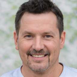 Joyful white adult male with short  brown hair and brown eyes