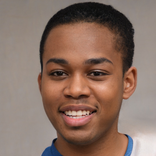 Joyful black young-adult male with short  brown hair and brown eyes