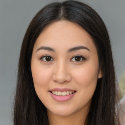 Joyful asian young-adult female with long  brown hair and brown eyes