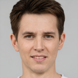 Joyful white young-adult male with short  brown hair and grey eyes