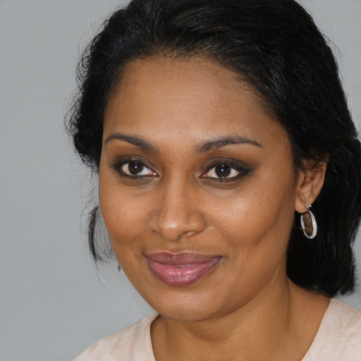 Joyful black young-adult female with medium  brown hair and brown eyes