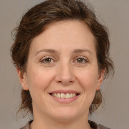 Joyful white adult female with medium  brown hair and grey eyes