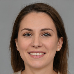 Joyful white young-adult female with medium  brown hair and grey eyes