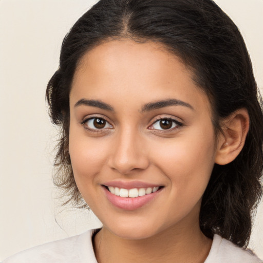 Joyful latino young-adult female with medium  brown hair and brown eyes