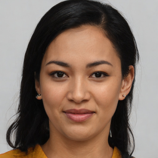 Joyful latino young-adult female with long  black hair and brown eyes