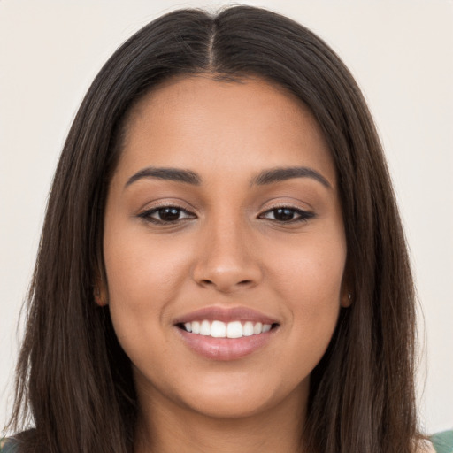 Joyful latino young-adult female with long  brown hair and brown eyes