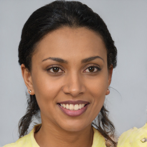 Joyful latino young-adult female with medium  brown hair and brown eyes