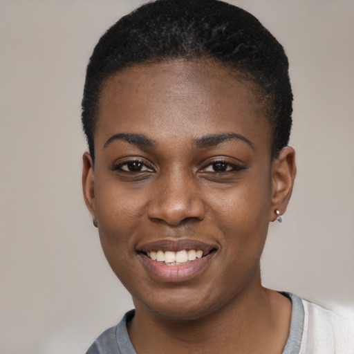 Joyful black young-adult female with short  black hair and brown eyes