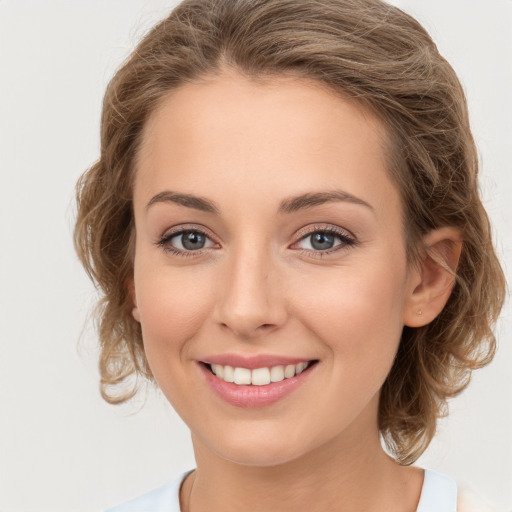 Joyful white young-adult female with medium  brown hair and green eyes