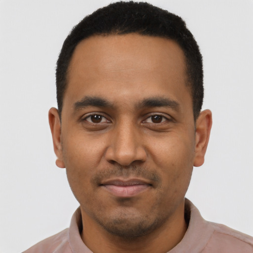 Joyful black young-adult male with short  black hair and brown eyes