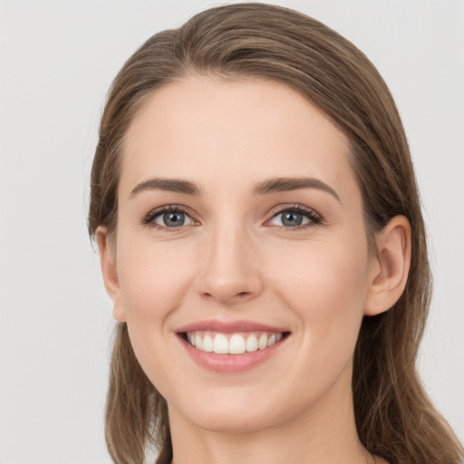 Joyful white young-adult female with long  brown hair and grey eyes