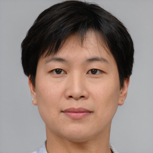 Joyful asian young-adult male with short  brown hair and brown eyes