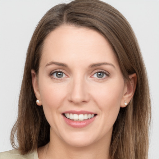 Joyful white young-adult female with long  brown hair and grey eyes