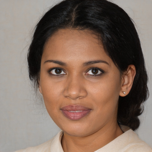 Joyful black young-adult female with medium  black hair and brown eyes