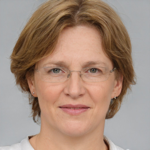 Joyful white adult female with medium  brown hair and blue eyes