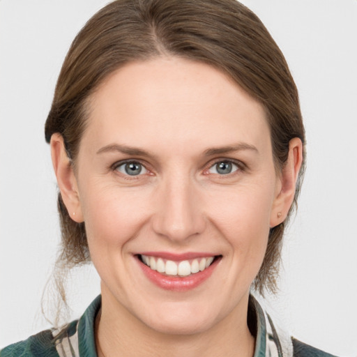 Joyful white young-adult female with medium  brown hair and grey eyes