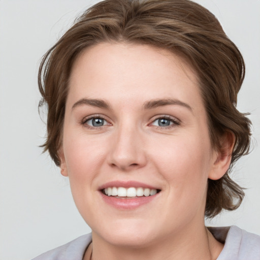 Joyful white young-adult female with medium  brown hair and blue eyes