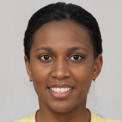 Joyful black young-adult female with short  black hair and brown eyes