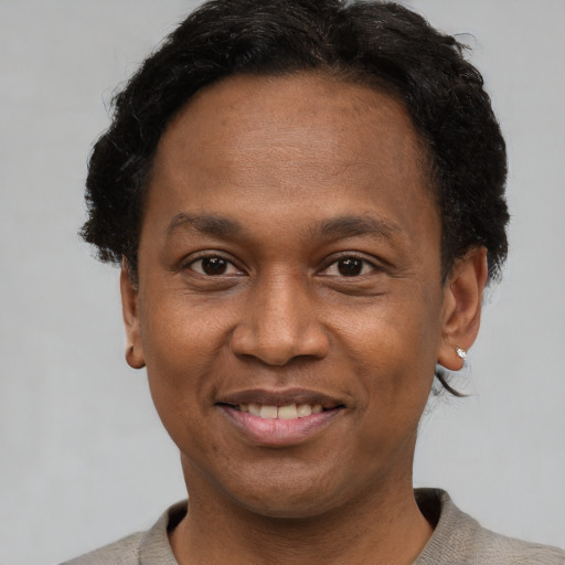 Joyful black adult male with short  brown hair and brown eyes