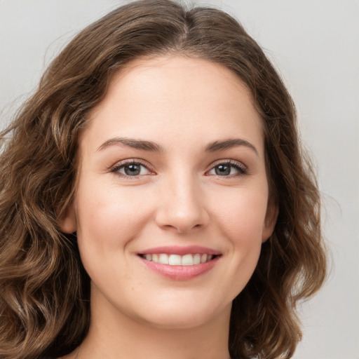 Joyful white young-adult female with long  brown hair and green eyes