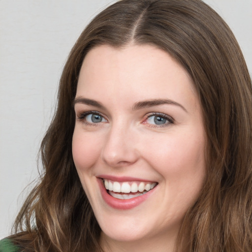 Joyful white young-adult female with long  brown hair and green eyes