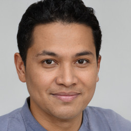 Joyful latino young-adult male with short  brown hair and brown eyes