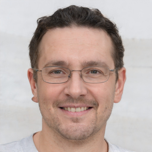 Joyful white adult male with short  brown hair and grey eyes