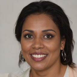 Joyful black adult female with medium  brown hair and brown eyes