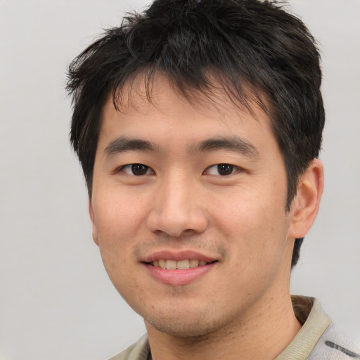 Joyful asian young-adult male with short  brown hair and brown eyes