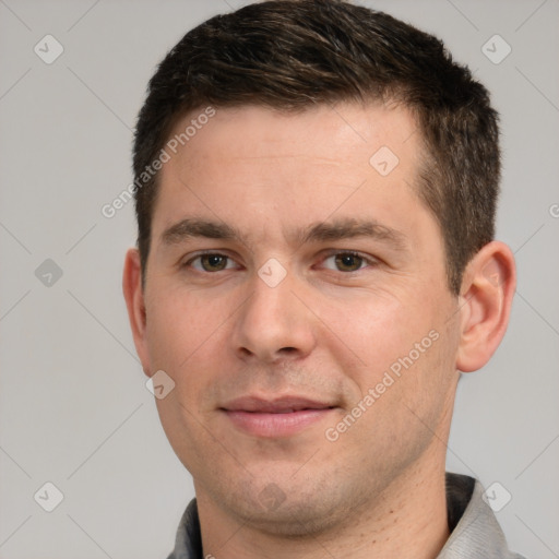 Joyful white young-adult male with short  brown hair and grey eyes