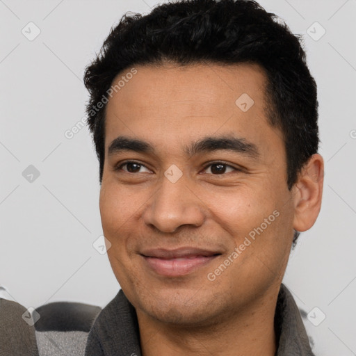 Joyful latino young-adult male with short  black hair and brown eyes